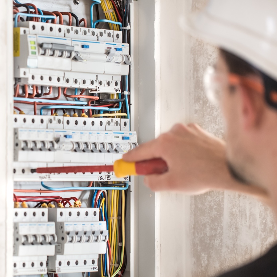 Intervention d’un électricien sur tableau de distribution Électricien travaillant sur tableau électrique