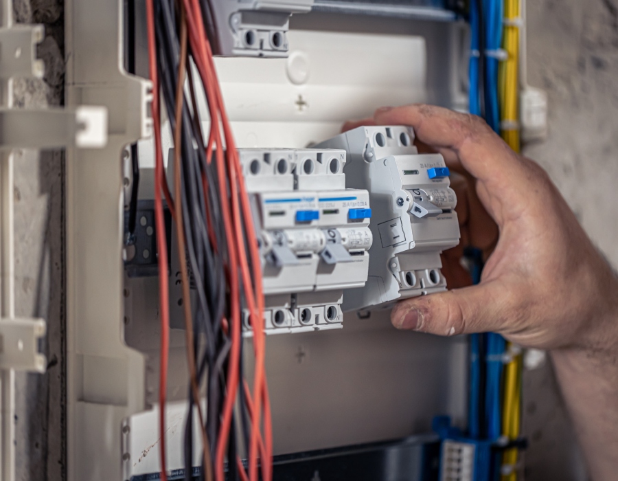 Électricien installant des disjoncteurs dans un tableau électrique résidentiel